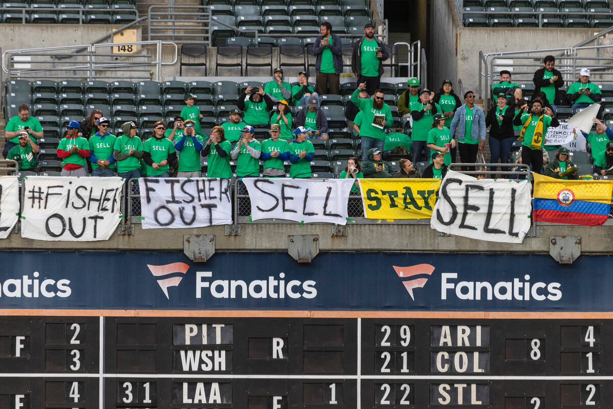 The Oakland A's fans display signs as they protest at the Oakland Coliseum during a baseball ga ...