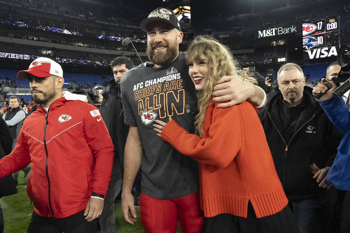 FILE - Kansas City Chiefs tight end Travis Kelce walks with Taylor Swift following the AFC Cham ...