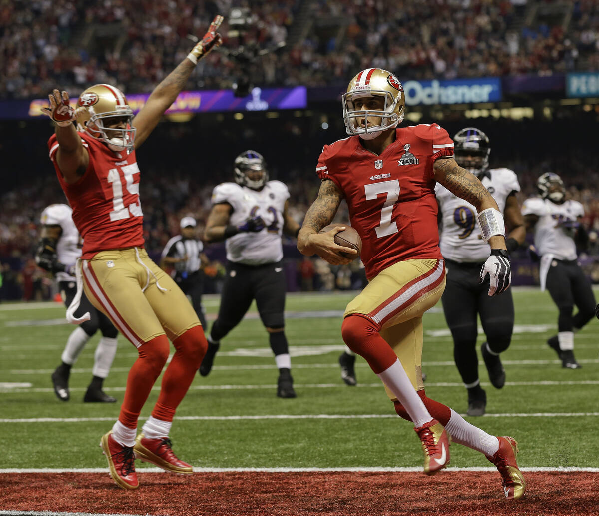 San Francisco 49ers quarterback Colin Kaepernick (7) crosses the goal line for a touchdown as w ...
