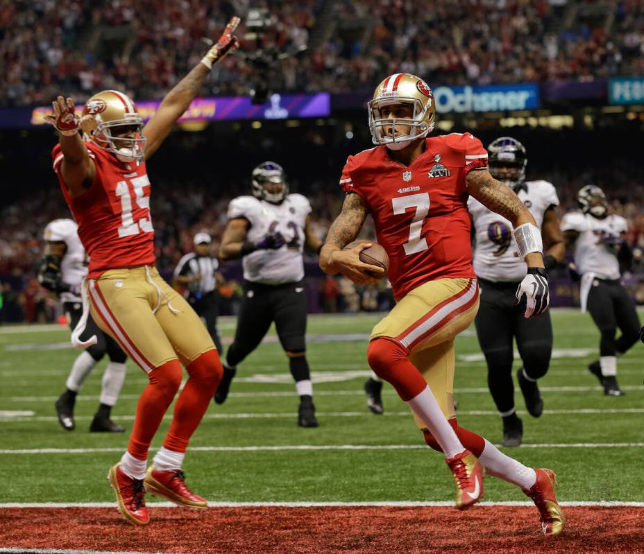 San Francisco 49ers quarterback Colin Kaepernick (7) crosses the goal line for a touchdown as w ...