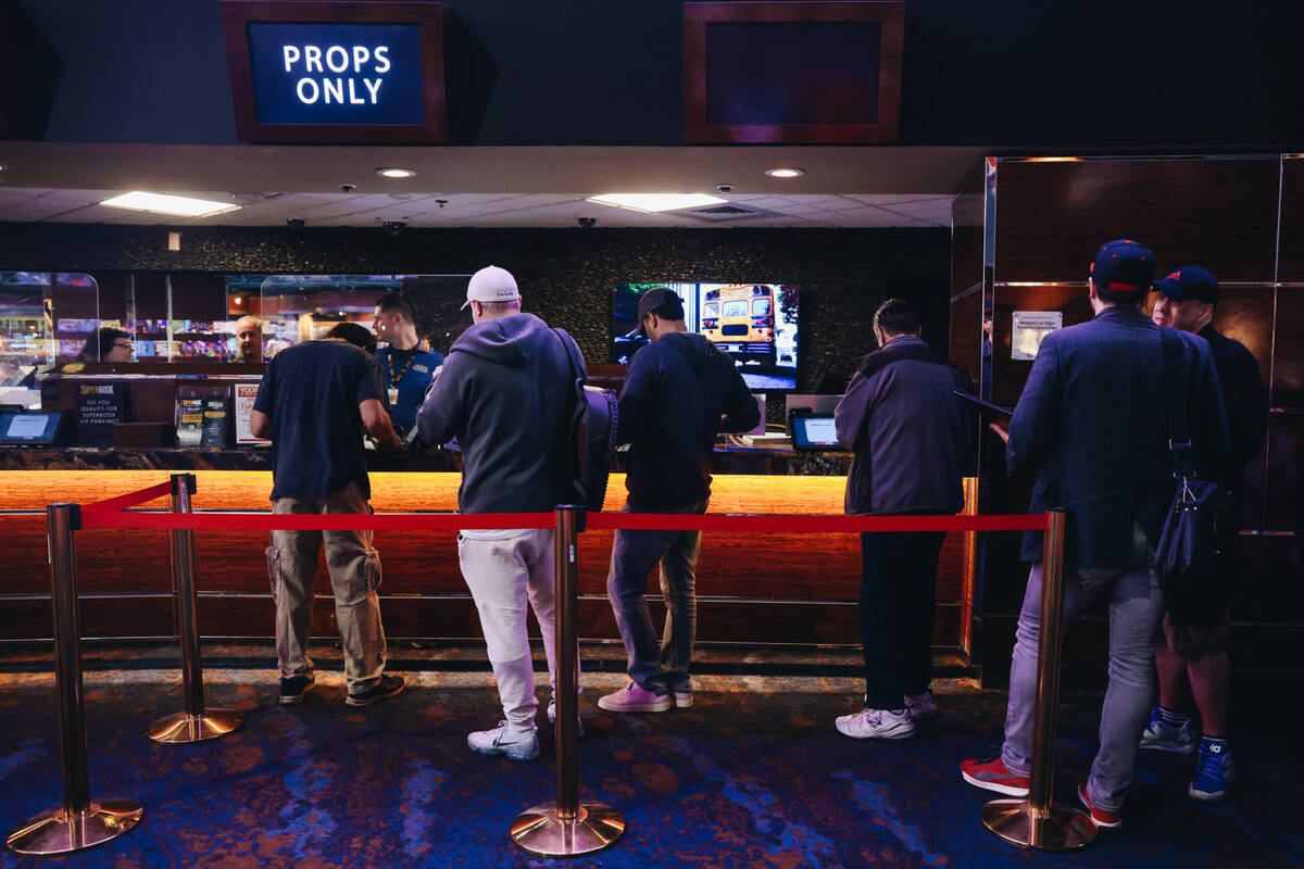 Bettors wait in line to cast bets from a menu of Super Bowl props at the Westgate SuperBook on ...