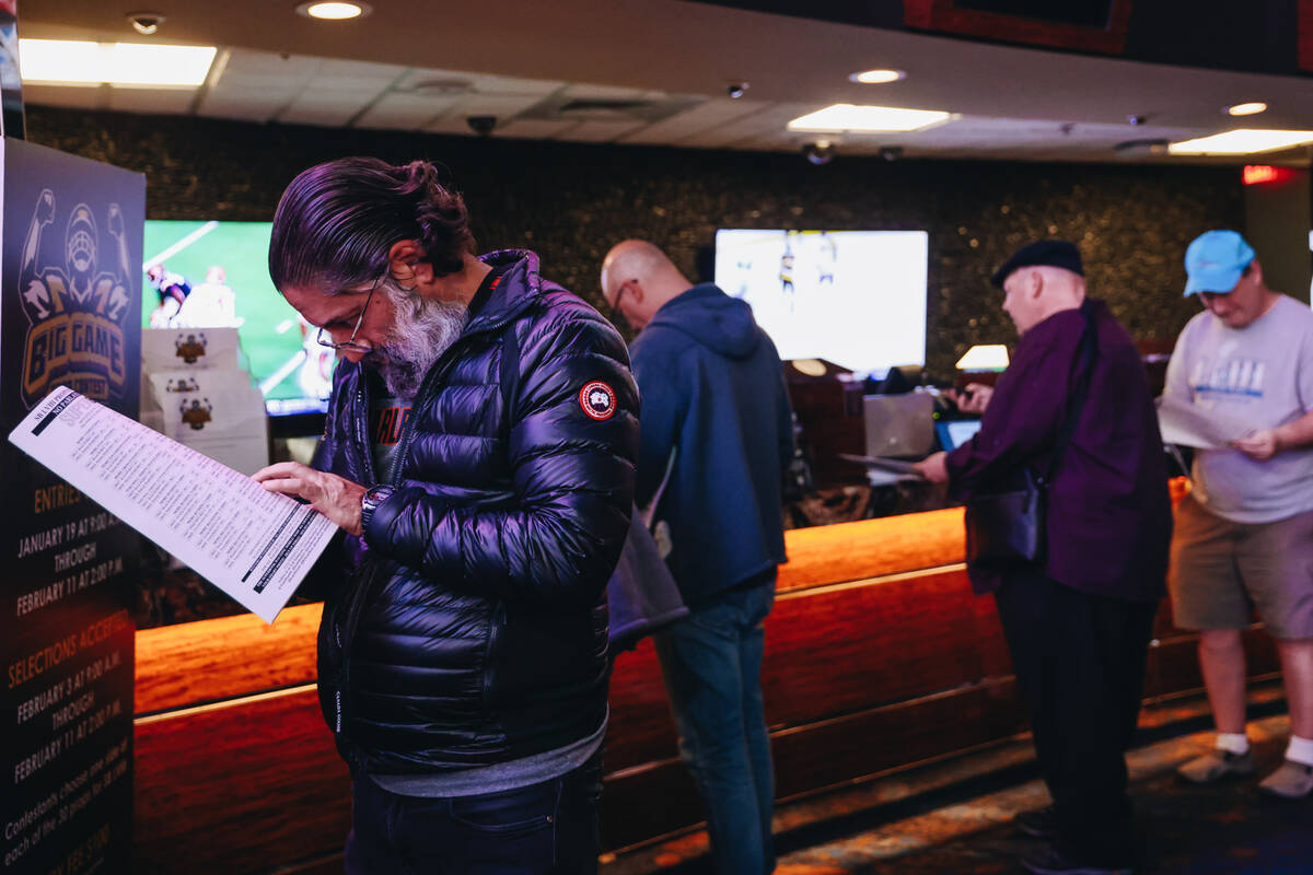 A bettor reads from a Super Bowl props packet before casting a bet at the Westgate SuperBook on ...