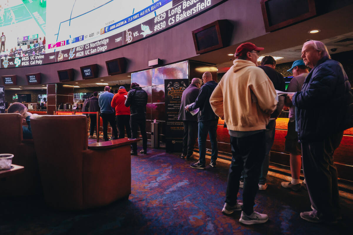 Bettors wait in line to cast bets from a menu of Super Bowl props at the Westgate SuperBook on ...