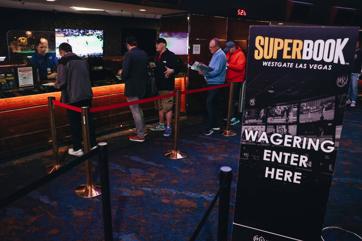 Bettors wait in line to cast bets from a menu of Super Bowl props at the Westgate SuperBook on ...
