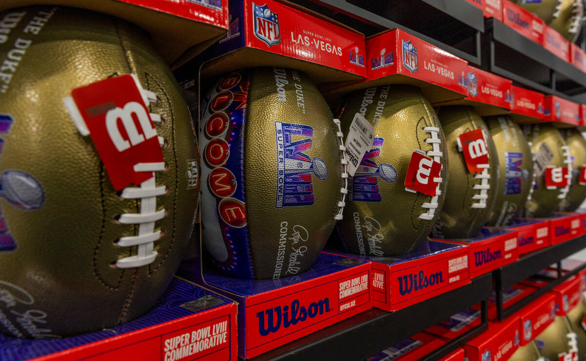 Commemorative footballs are stacked up for sale within the NFL Shop being is set up for the Sup ...