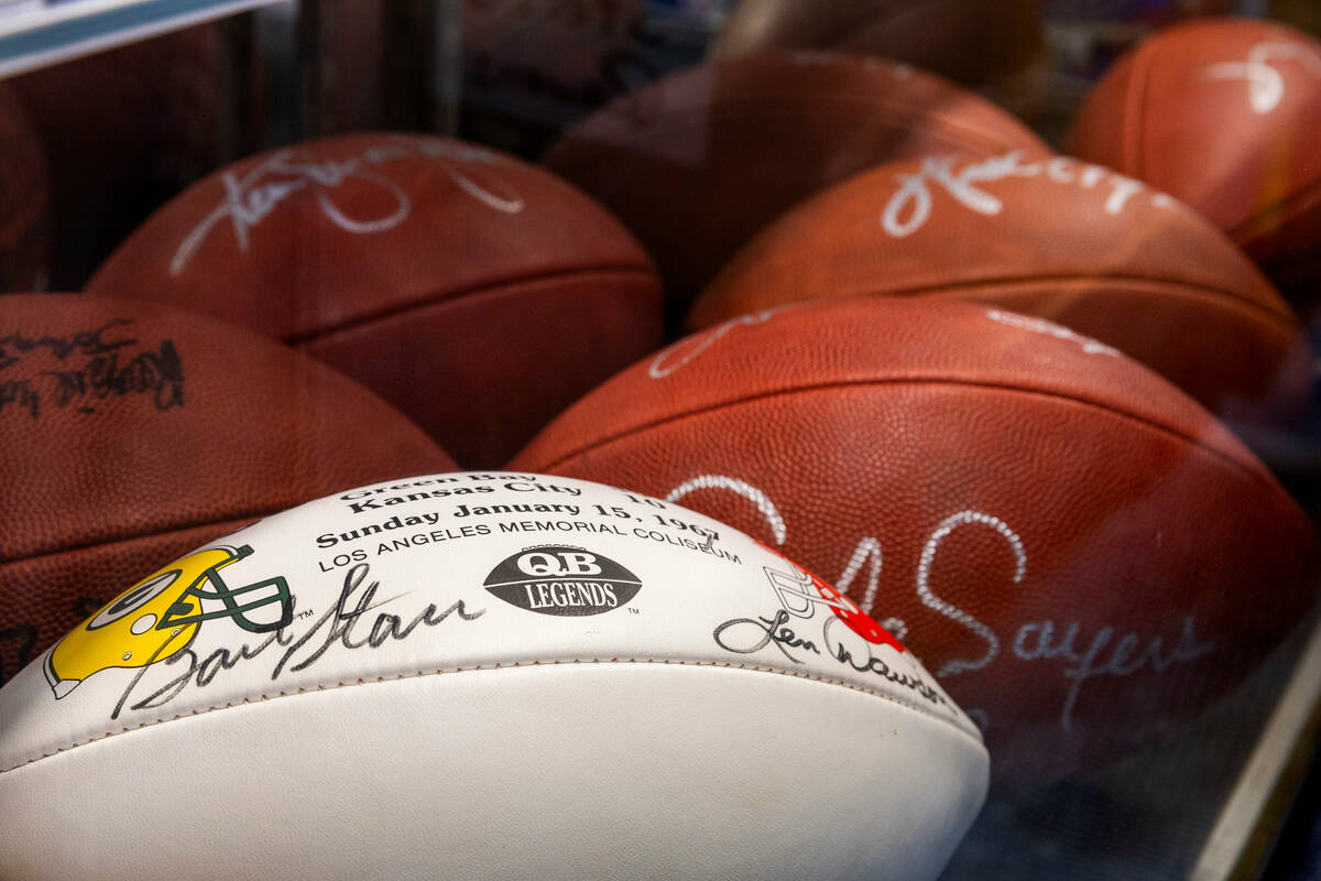 Autographed footballs are in a case for sale within the NFL Shop being is set up for the Super ...