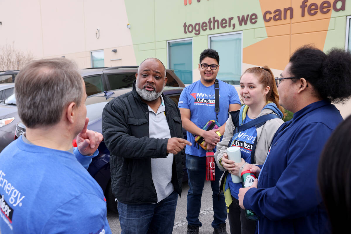 U.S. Attorney Jason Frierson, second from left, visits with NV Energy volunteers during a servi ...