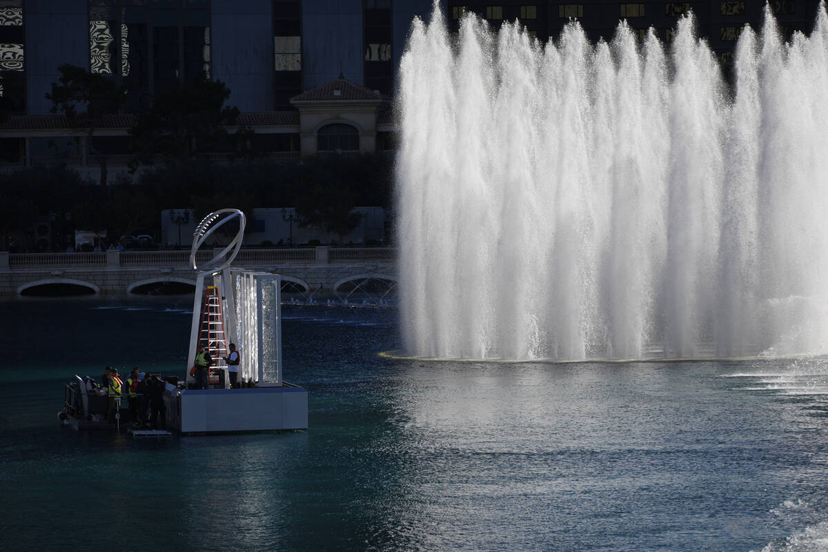Workers erect a Lombardi Trophy statue at the Bellagio fountains ahead of the Super Bowl 58 foo ...