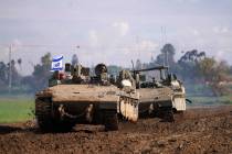 Israeli soldiers drive in their armored vehicles in southern Israel near the border with the Ga ...