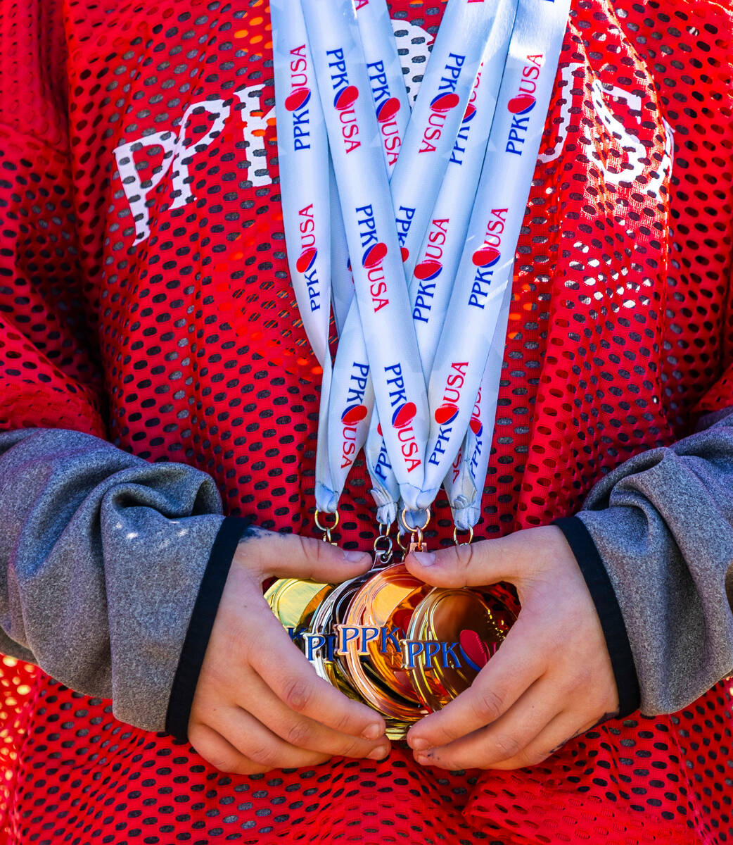 Kanin Johnson of Conrad, Montana, a 6/7-year-old boy's contestant, holds a handful of medals du ...
