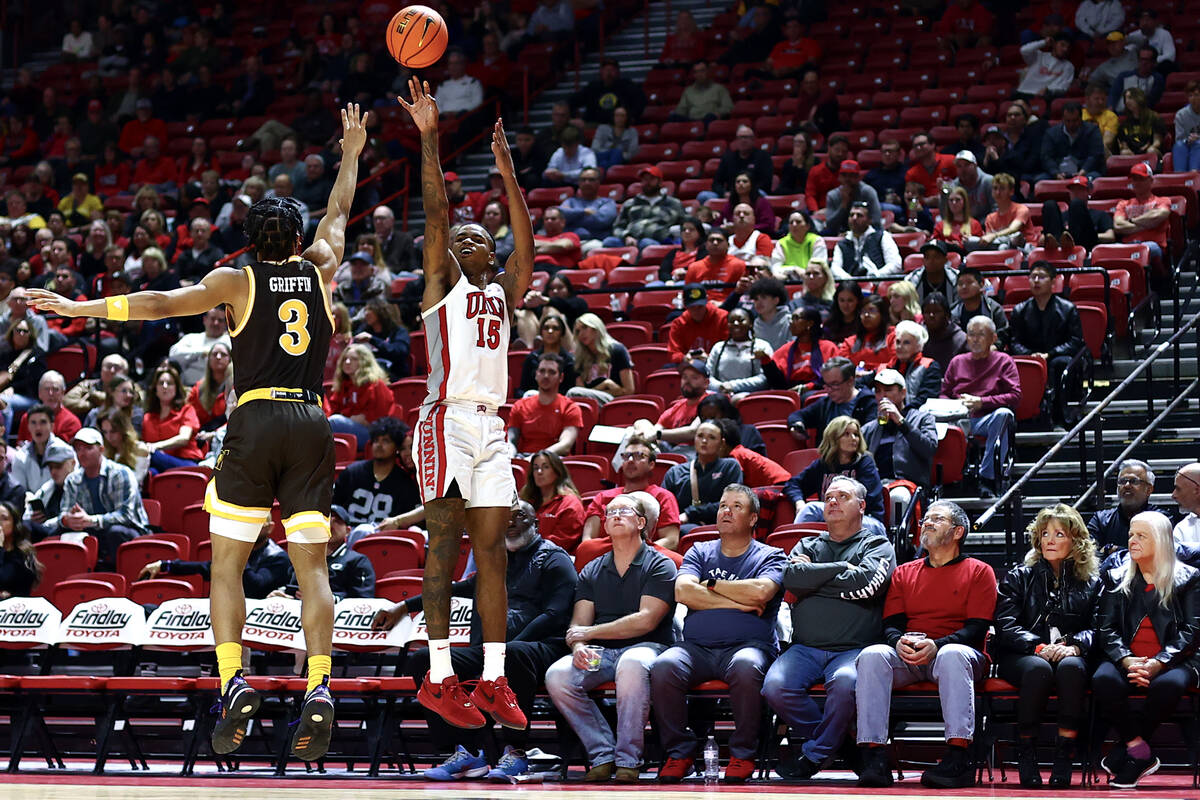 UNLV Rebels guard Luis Rodriguez (15) shoots against Wyoming Cowboys guard Sam Griffin (3) duri ...