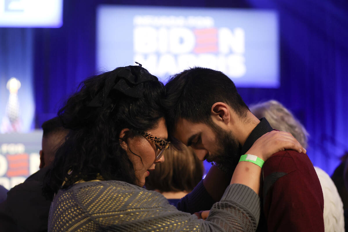 A couple shares a moment while waiting for President Joe Biden to speak during a campaign event ...