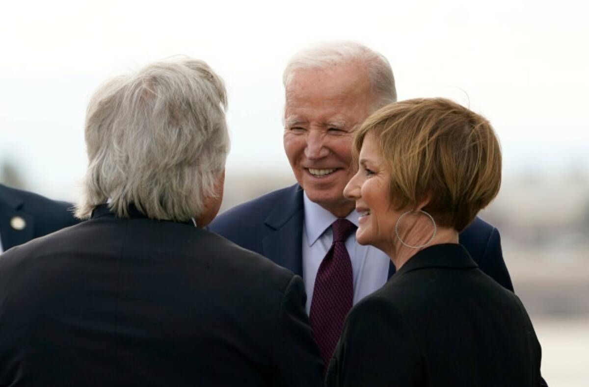 President Joe Biden, center, greets Tick Segerblom, chairman of the Clark County Commissioners, ...
