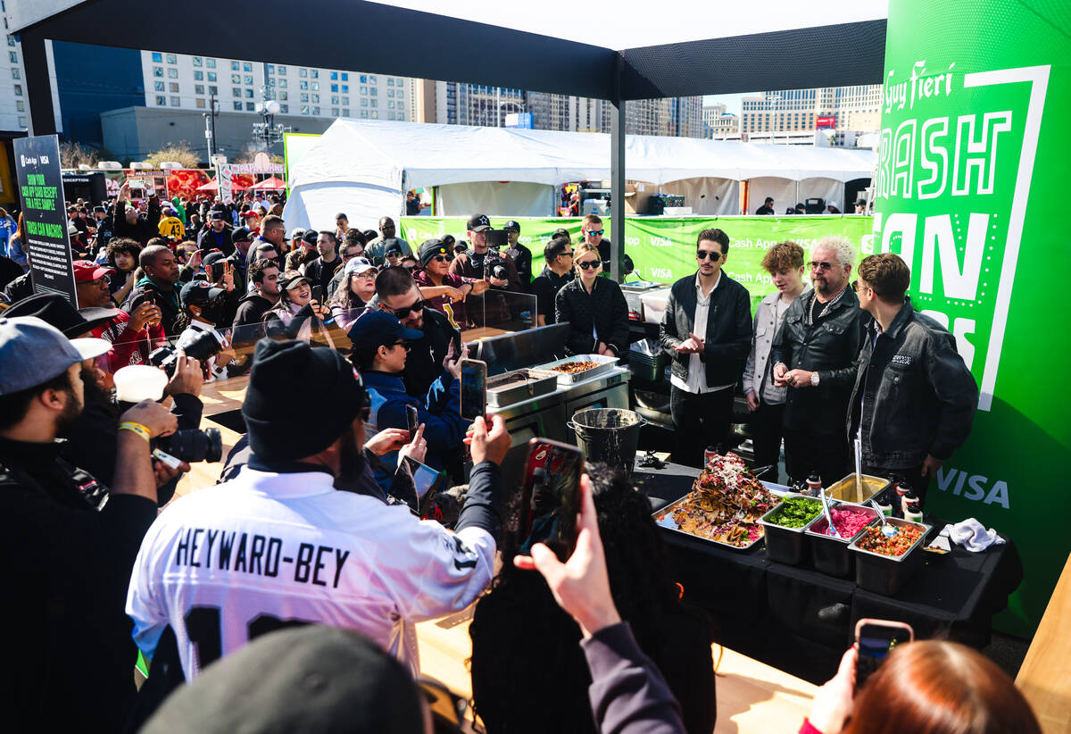 Celebrity chef Guy Fieri addresses the crowd with his nephew Jules Fieri, from left, son Ryder ...