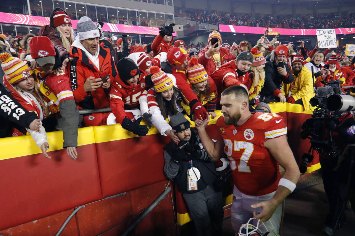 Kansas City Chiefs tight end Travis Kelce (87) celebrates with fans as he walks off the field a ...