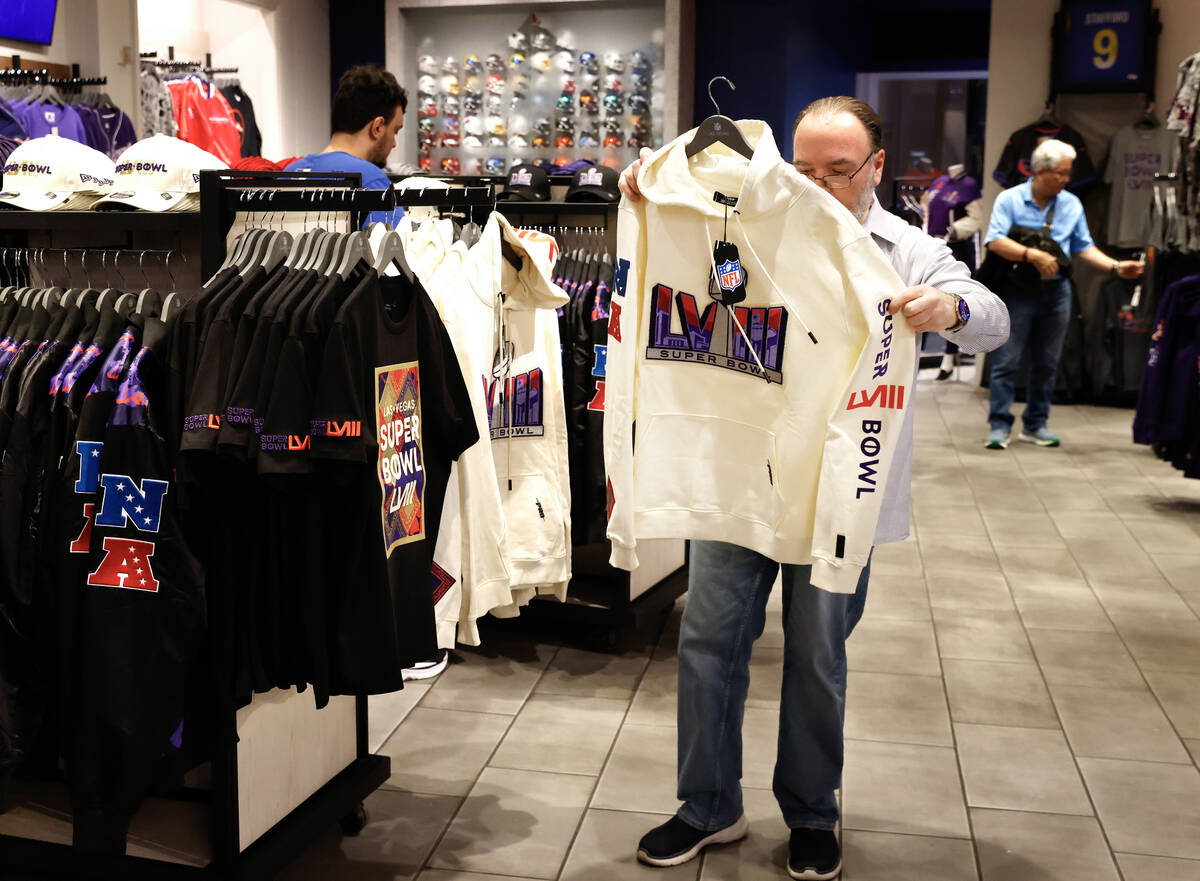 Shoppers check out Super Bowl LVIII merchandise at the NFL Las Vegas store at the Forum Shop, o ...