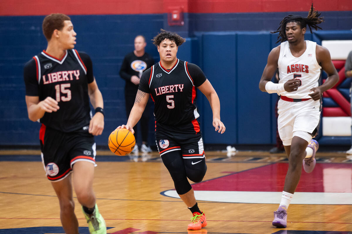 Liberty’s Andre Porter (5) dribbles the ball down the court during a basketball game bet ...