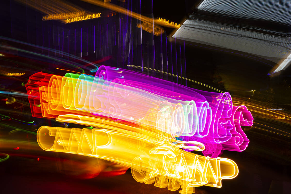 A long exposure photograph of a neon sign for Frooog’s Camp House, outside of the Luxor, on W ...