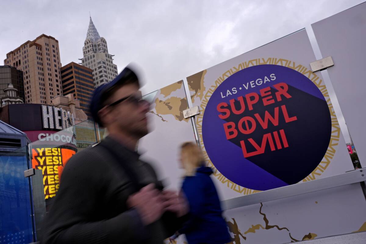 Pedestrians walk past signage for NFL Super Bowl 58 Tuesday, Feb. 6, 2024 in Las Vegas. The Kan ...