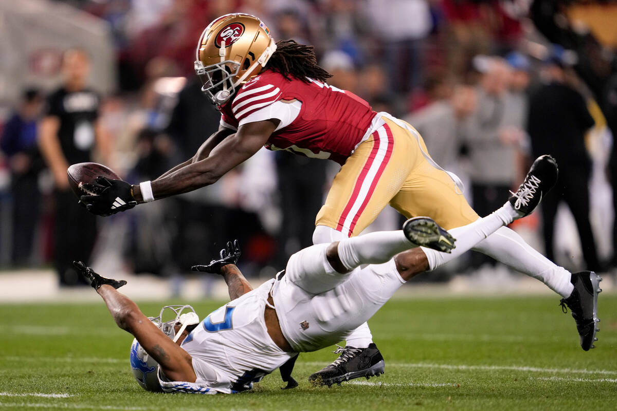 San Francisco 49ers wide receiver Brandon Aiyuk, top, catches a pass against Detroit Lions corn ...