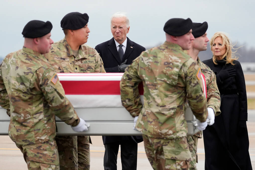President Joe Biden and first lady Jill Biden watch as an Army carry team moves the flag-draped ...