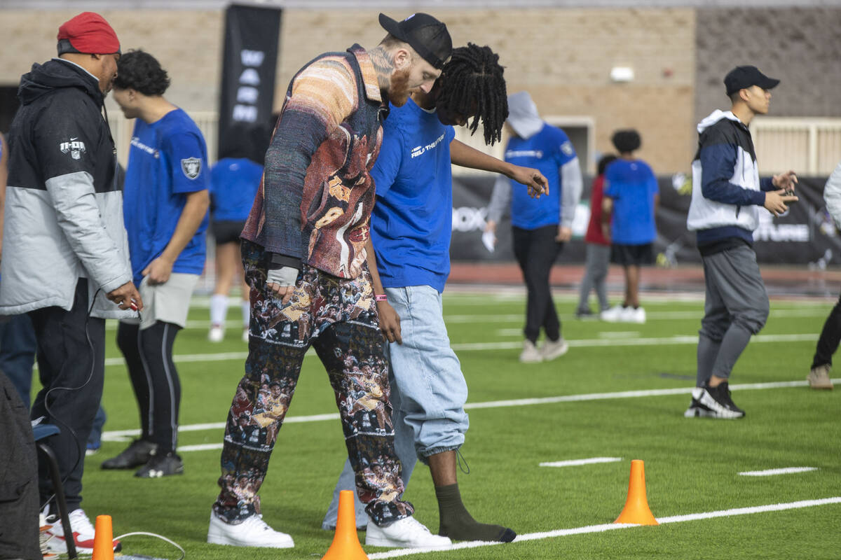 Raiders defensive end Maxx Crosby works with a participant of the Field the Future Madden NFL E ...