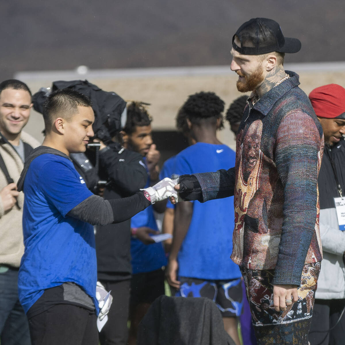 Raiders defensive end Maxx Crosby, right, shakes hands with a participant of the Field the Futu ...