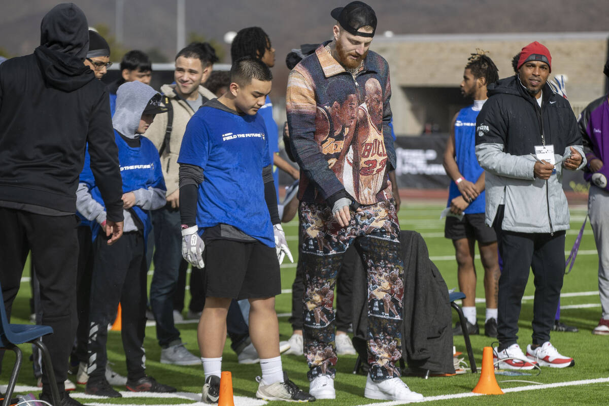 Raiders defensive end Maxx Crosby, left, works with a participant of the Field the Future Madde ...