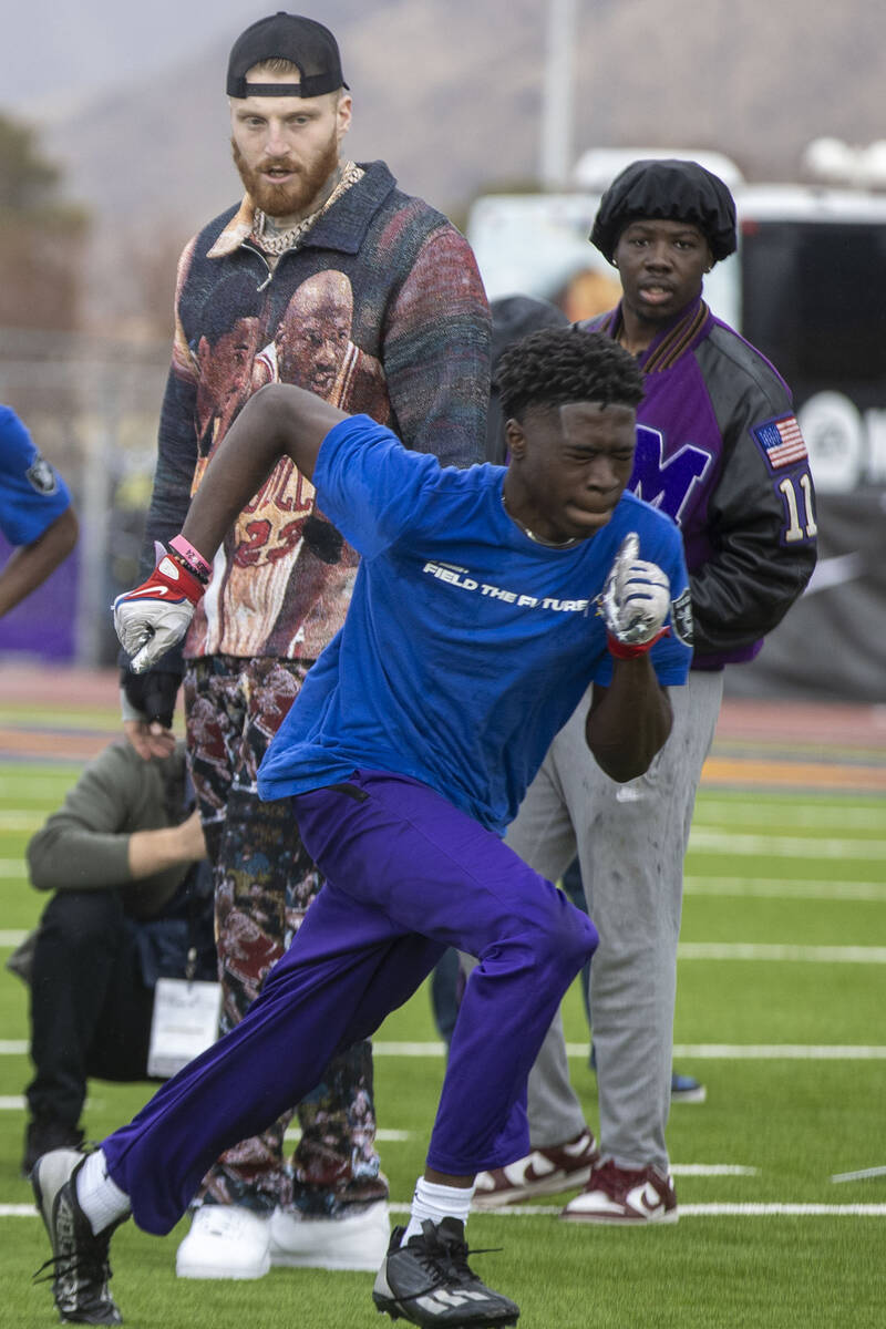 Raiders defensive end Maxx Crosby, left, looks on as a participant of the Field the Future Madd ...