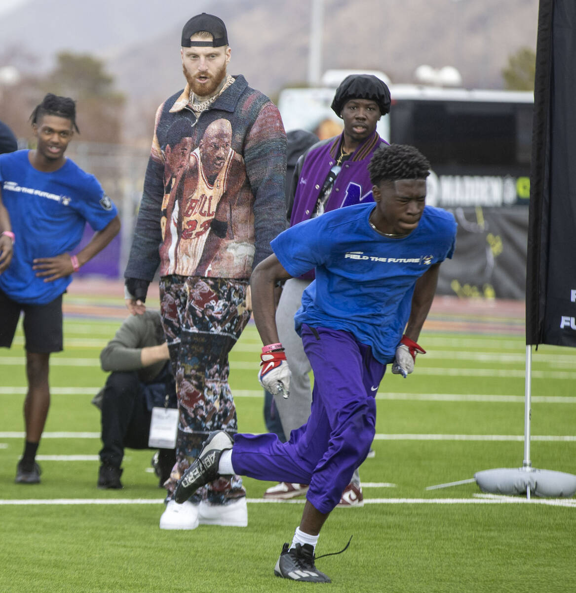 Raiders defensive end Maxx Crosby, left, looks on as a participant of the Field the Future Madd ...