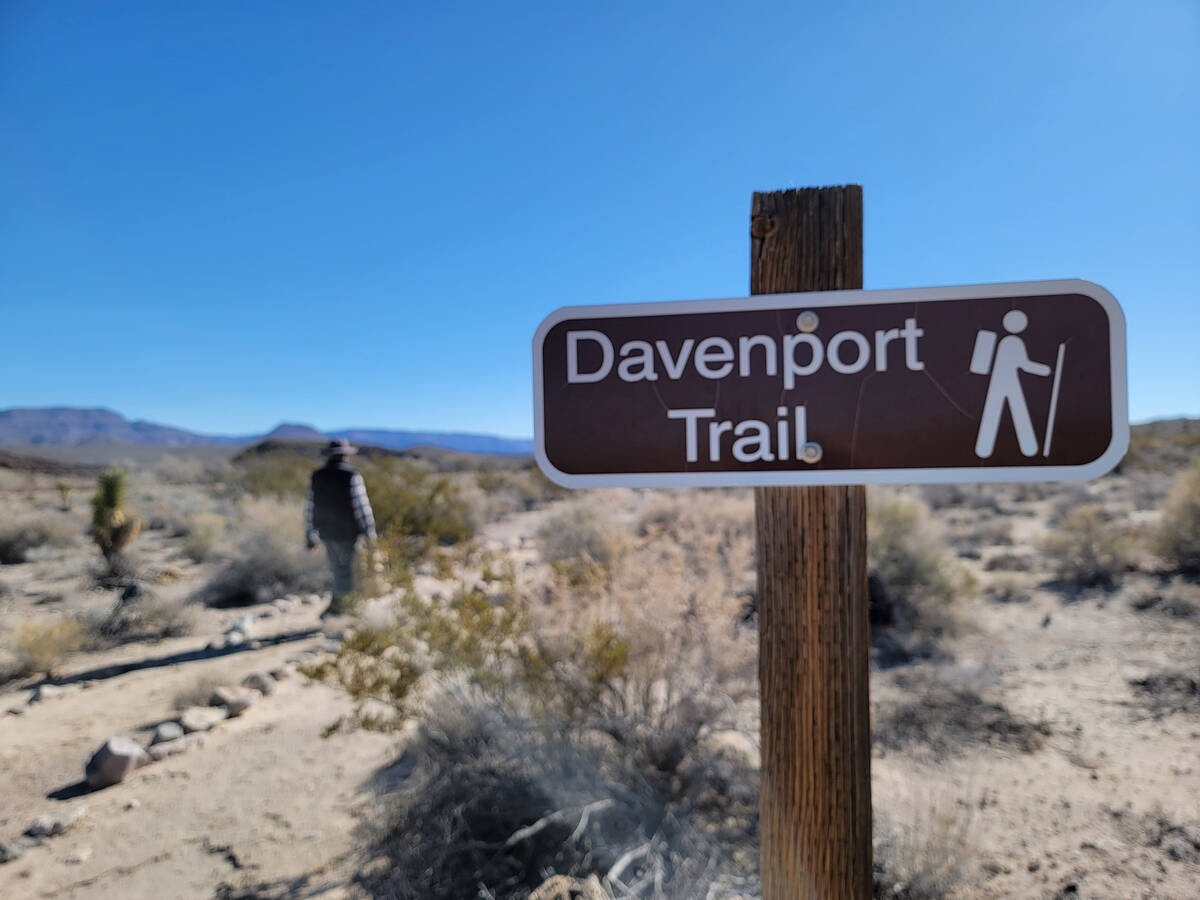 A hiker walks past the Davenport Trail sign and toward the refuge’s visitor center from ...