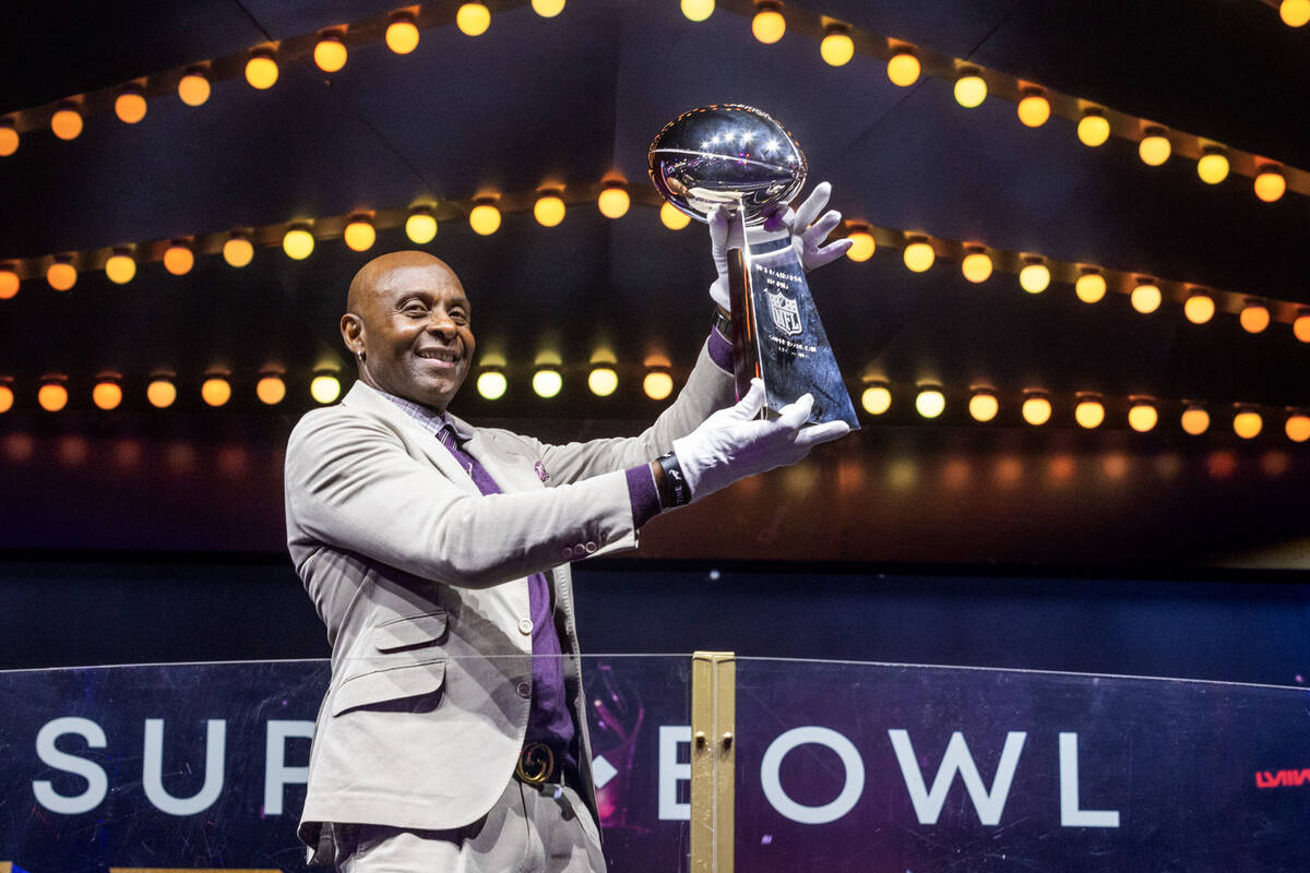 NFL great Jerry Rice shows off the Lombardi Trophy after carrying it in from a FedEx truck for ...