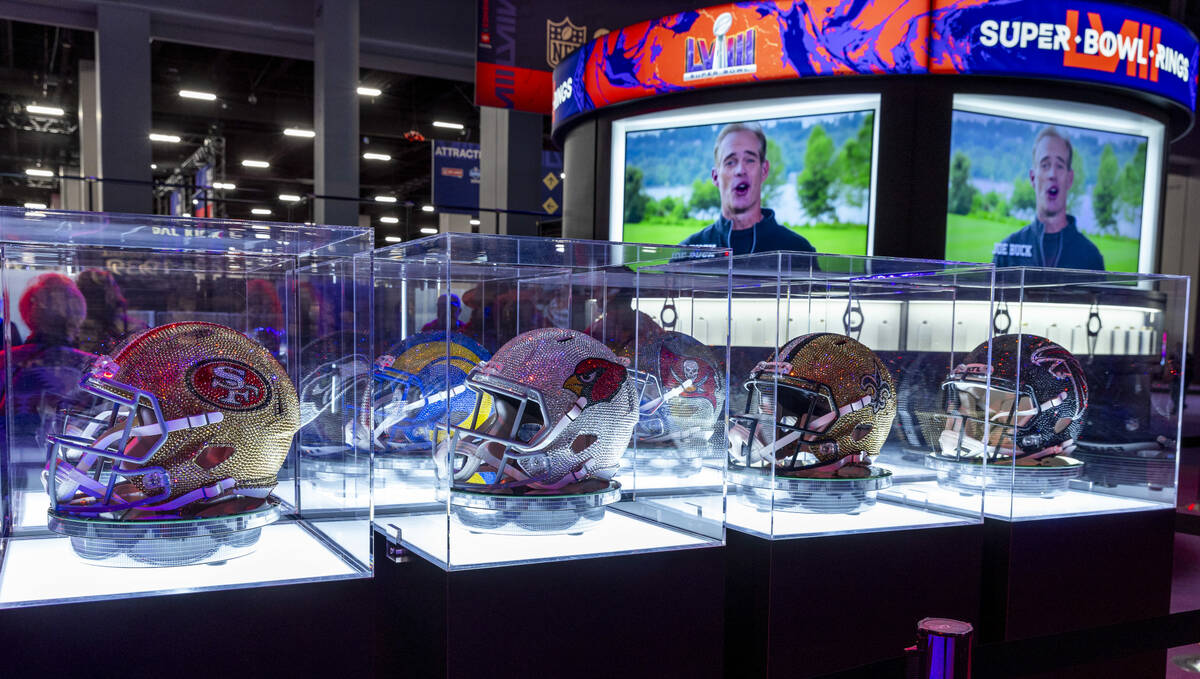 Helmets are all covered in crystals on display during the Super Bowl Experience at the Mandalay ...
