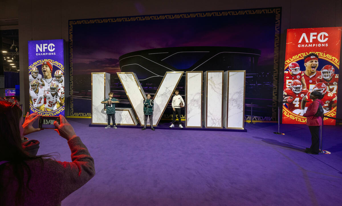 Fans pose for a photo at a numbers display during the Super Bowl Experience at the Mandalay Bay ...