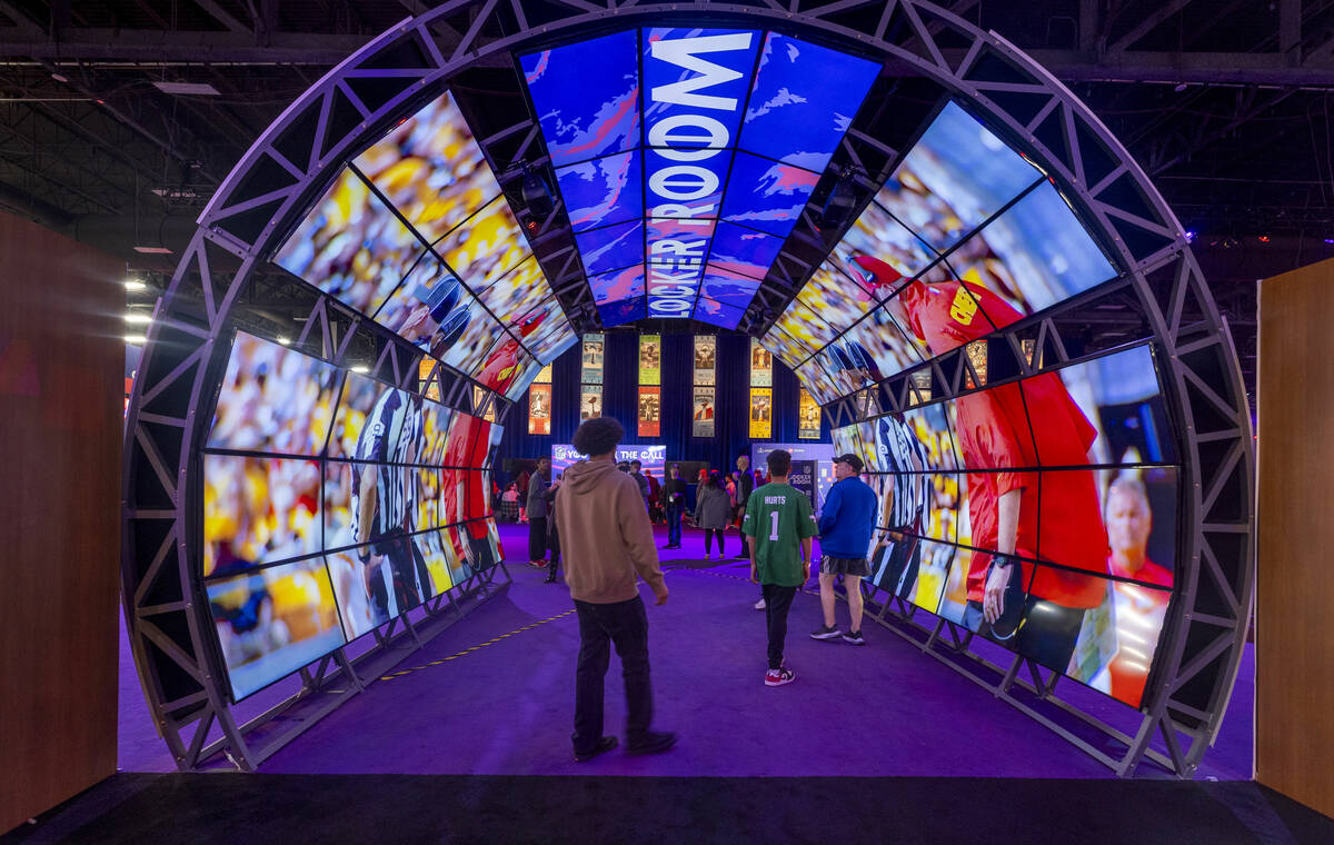 Fans walk through a video archway during the Super Bowl Experience at the Mandalay Bay Conventi ...