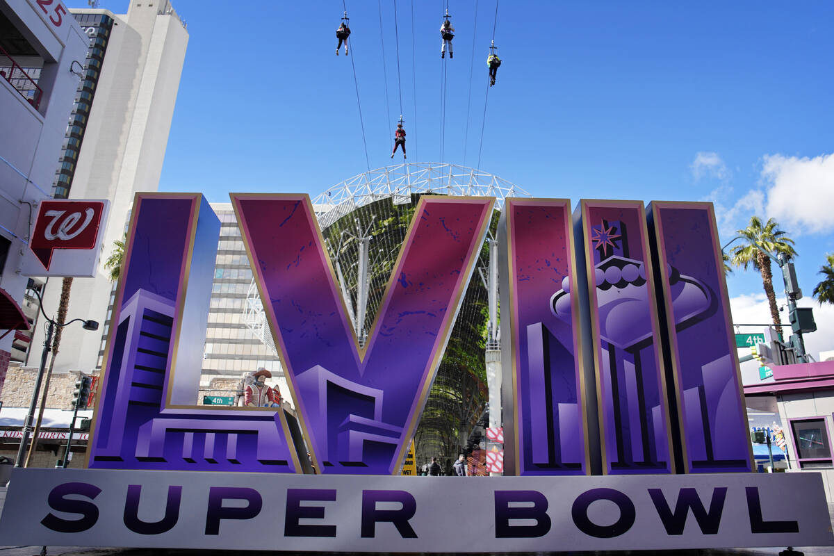 People ride a zip line above a sign for the Super Bowl ahead of the Super Bowl 58 NFL football ...