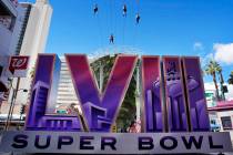 People ride a zip line above a sign for the Super Bowl ahead of the Super Bowl 58 NFL football ...