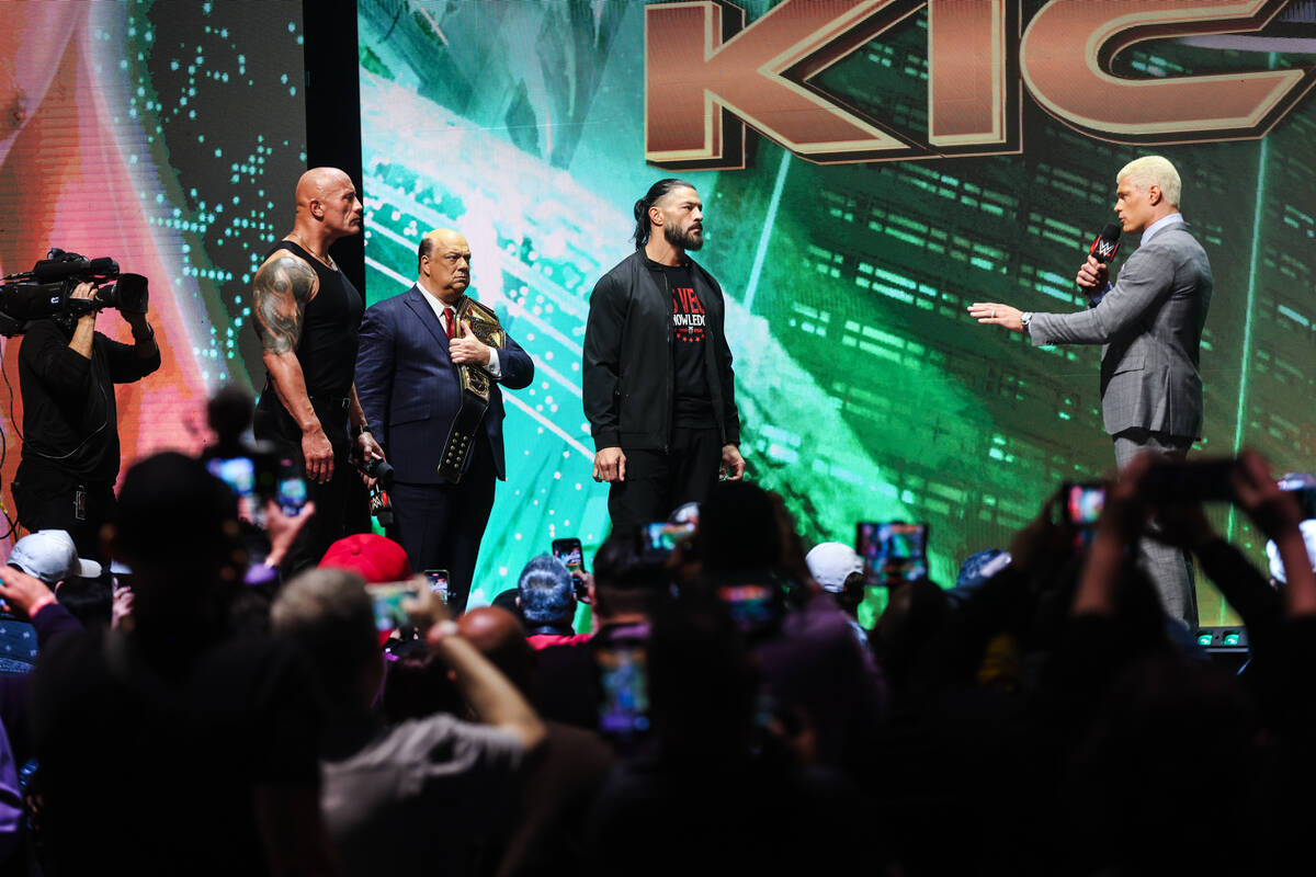 Pro wrestlers Dwayne “The Rock” Johnson, left, Roman Reigns, center, and Cody Rho ...
