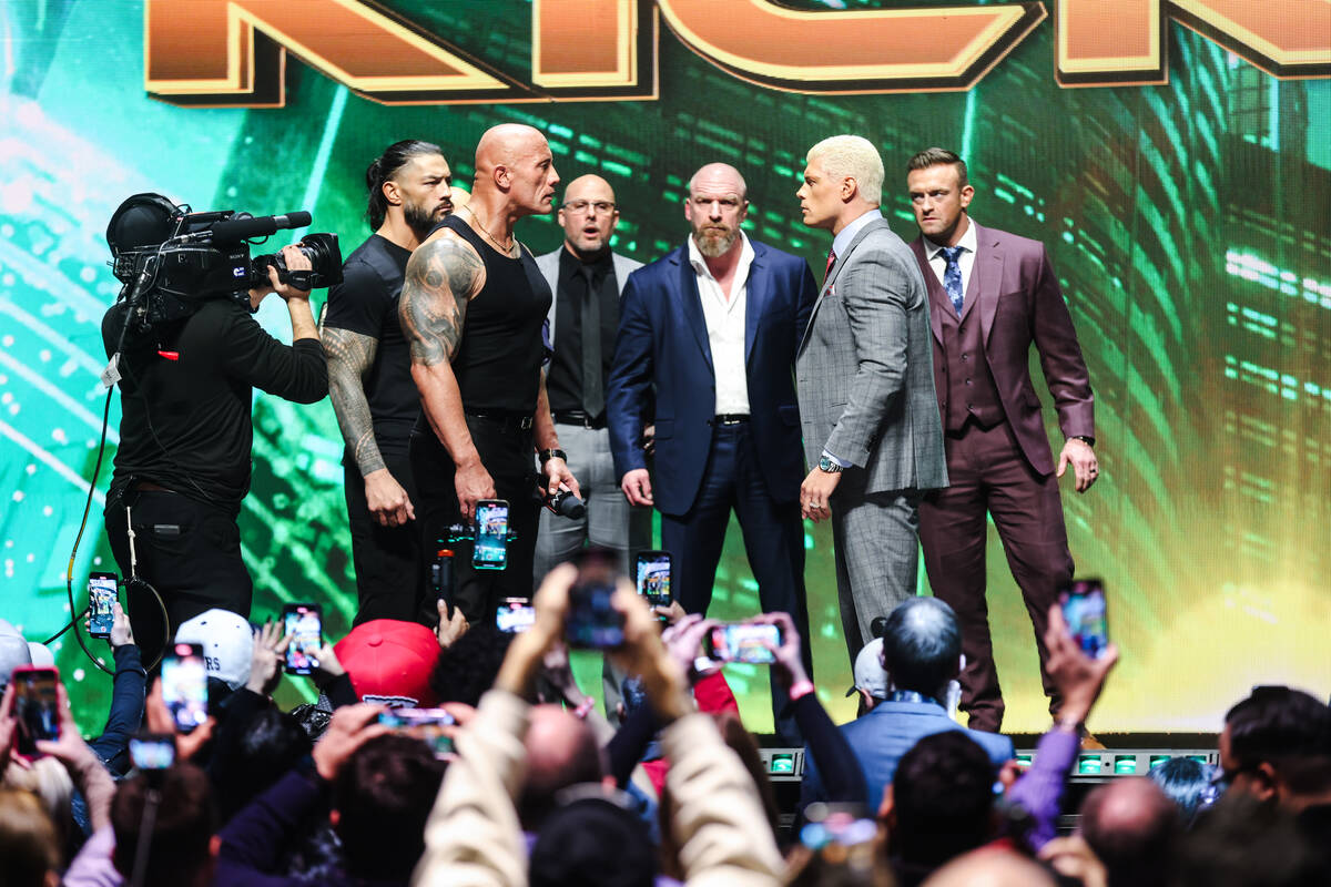 Pro wrestlers Dwayne “The Rock” Johnson, left, Roman Reigns, and Cody Rhodes, rig ...