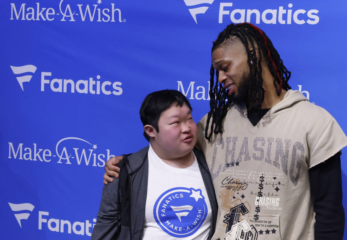 Bills' Damar Hamlin chats with Samuel Long as they pose for a photo at the Lids Flagship Store, ...