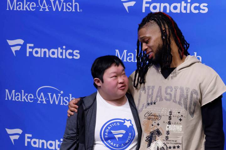 Bills' Damar Hamlin chats with Samuel Long as they pose for a photo at the Lids Flagship Store, ...