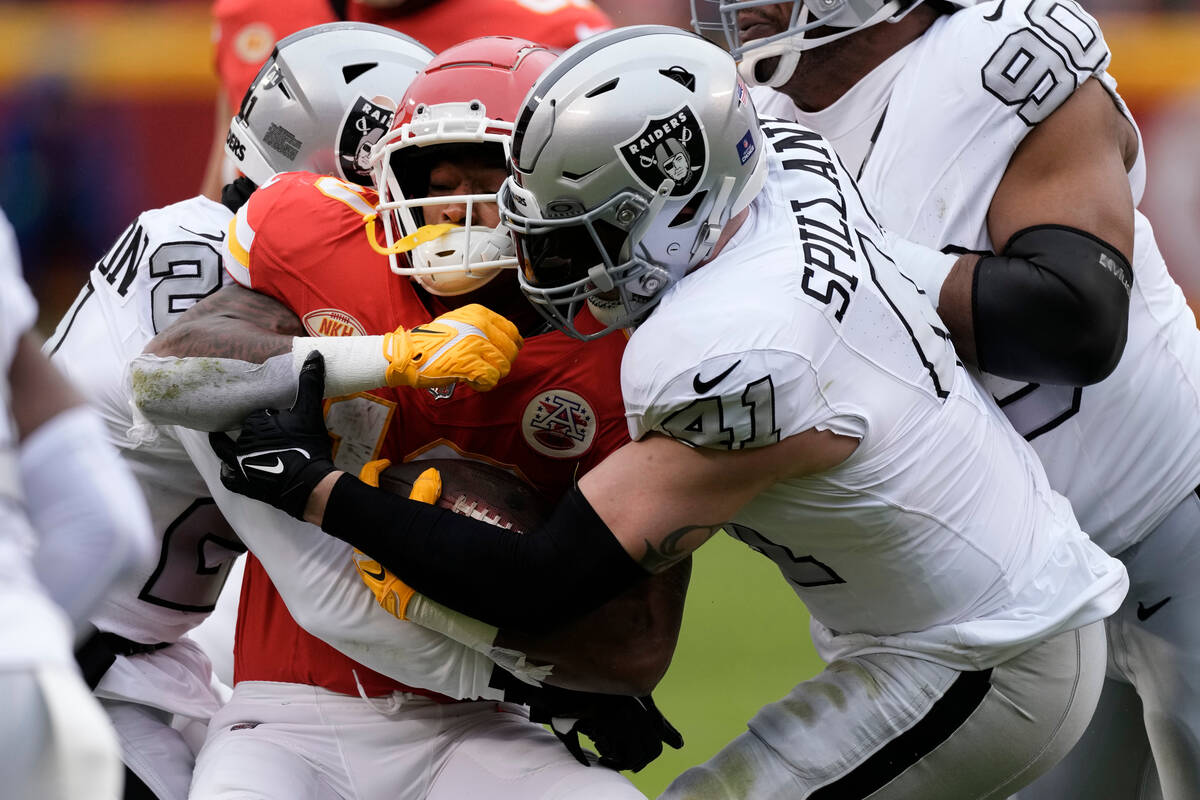 Kansas City Chiefs running back Isiah Pacheco, left, is stopped by Las Vegas Raiders linebacker ...
