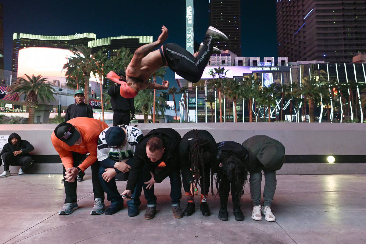 A street performer leaps over tourists on the Strip the day before Super Bowl LVIII Saturday, F ...
