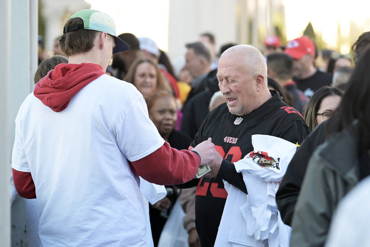 A San Francisco 49ers fan purchases T-shirts from a vendor on a pedestrian bridge over the Stip ...