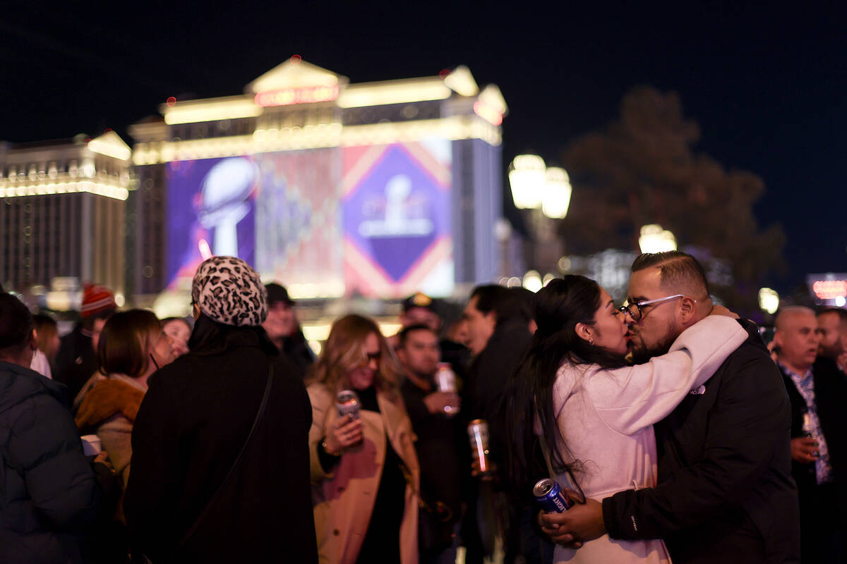 A couple shares a kiss as festivities for the Super Bowl are underway Saturday, Feb. 10, 2024, ...