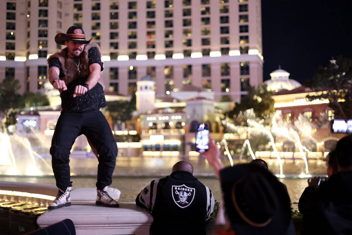 San Francisco 49ers fan Chris George, of Australia, dances in front of the Bellagio Fountains S ...