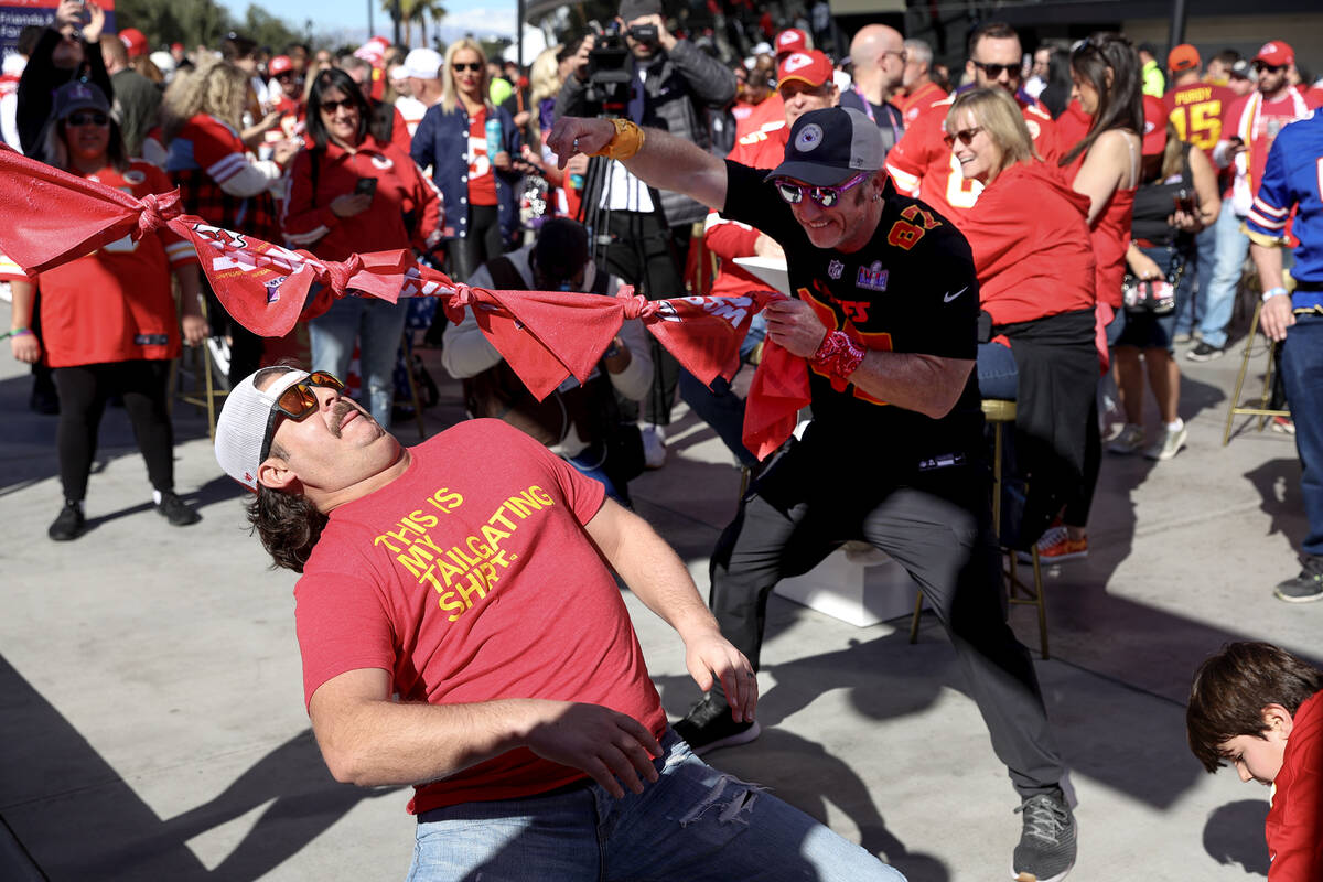 Kansas City Chiefs fan Mark Breuninger, of Kansas City, participates in a limbo contest before ...