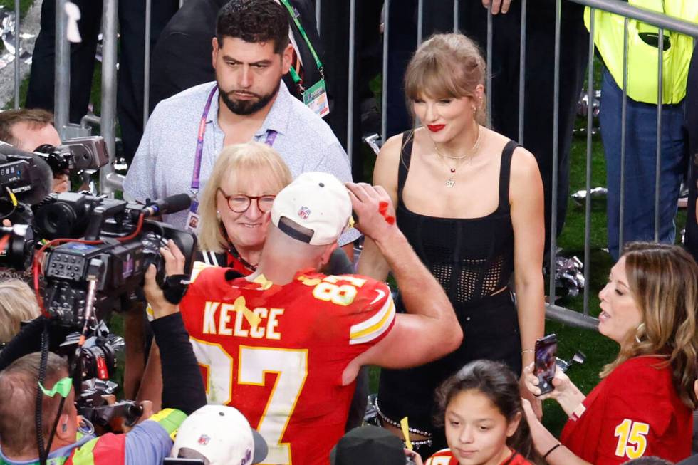 Kansas City Chiefs tight end Travis Kelce (87) greets Taylor Swift as he celebrates their victo ...