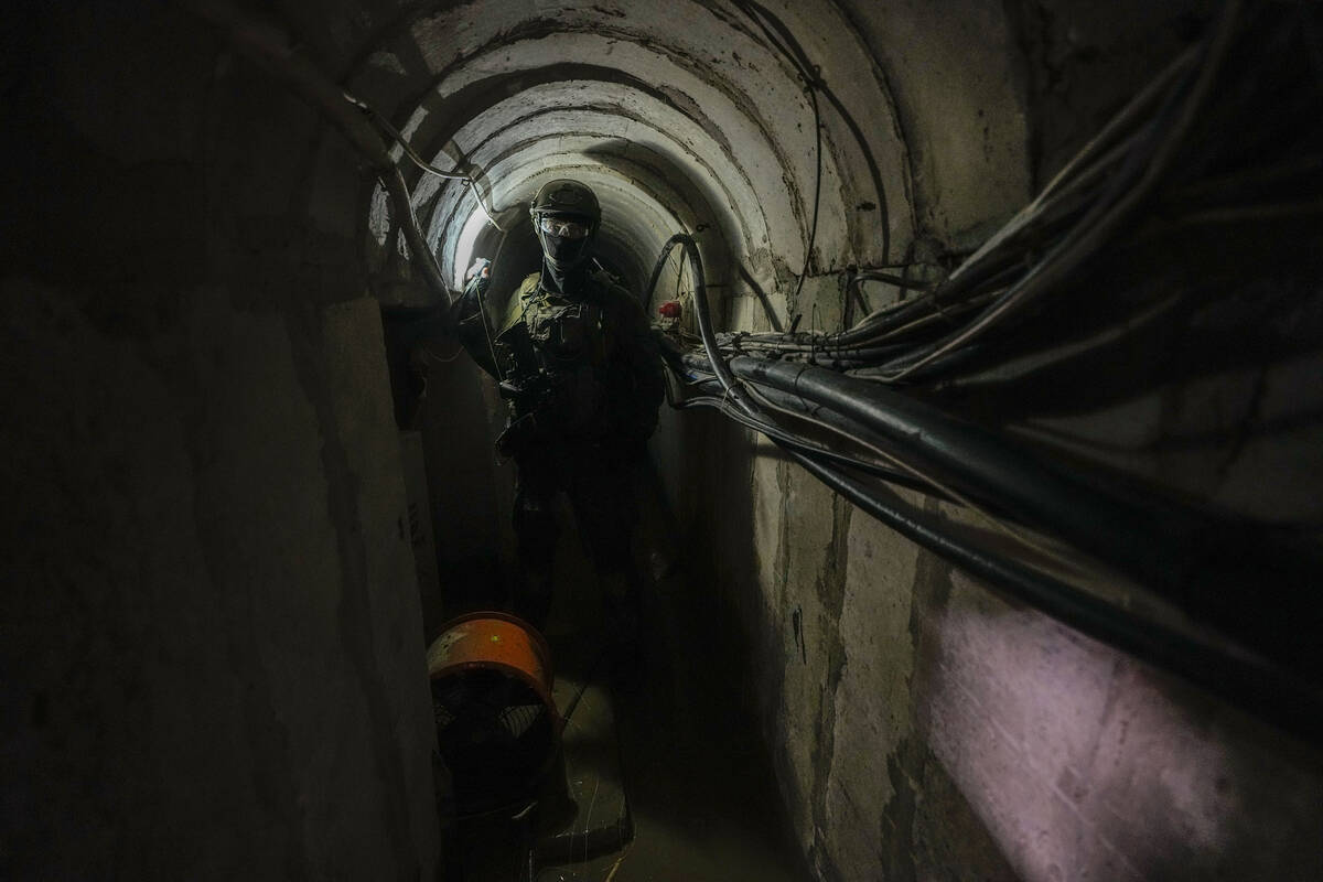 An Israeli soldier holds a light inside a tunnel underneath UNRWA compound, where the military ...