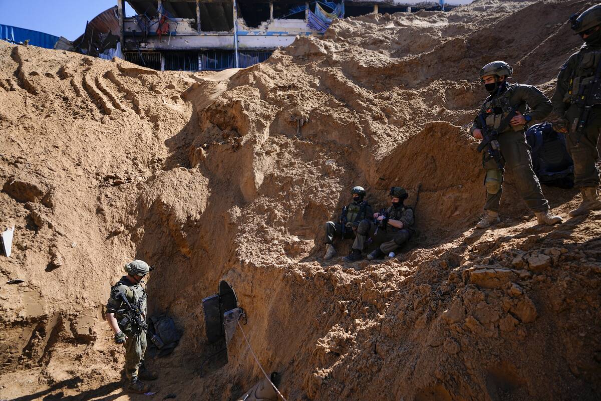 Israeli soldiers guard a crater-like hole giving way to a small tunnel entrance in the UNRWA co ...